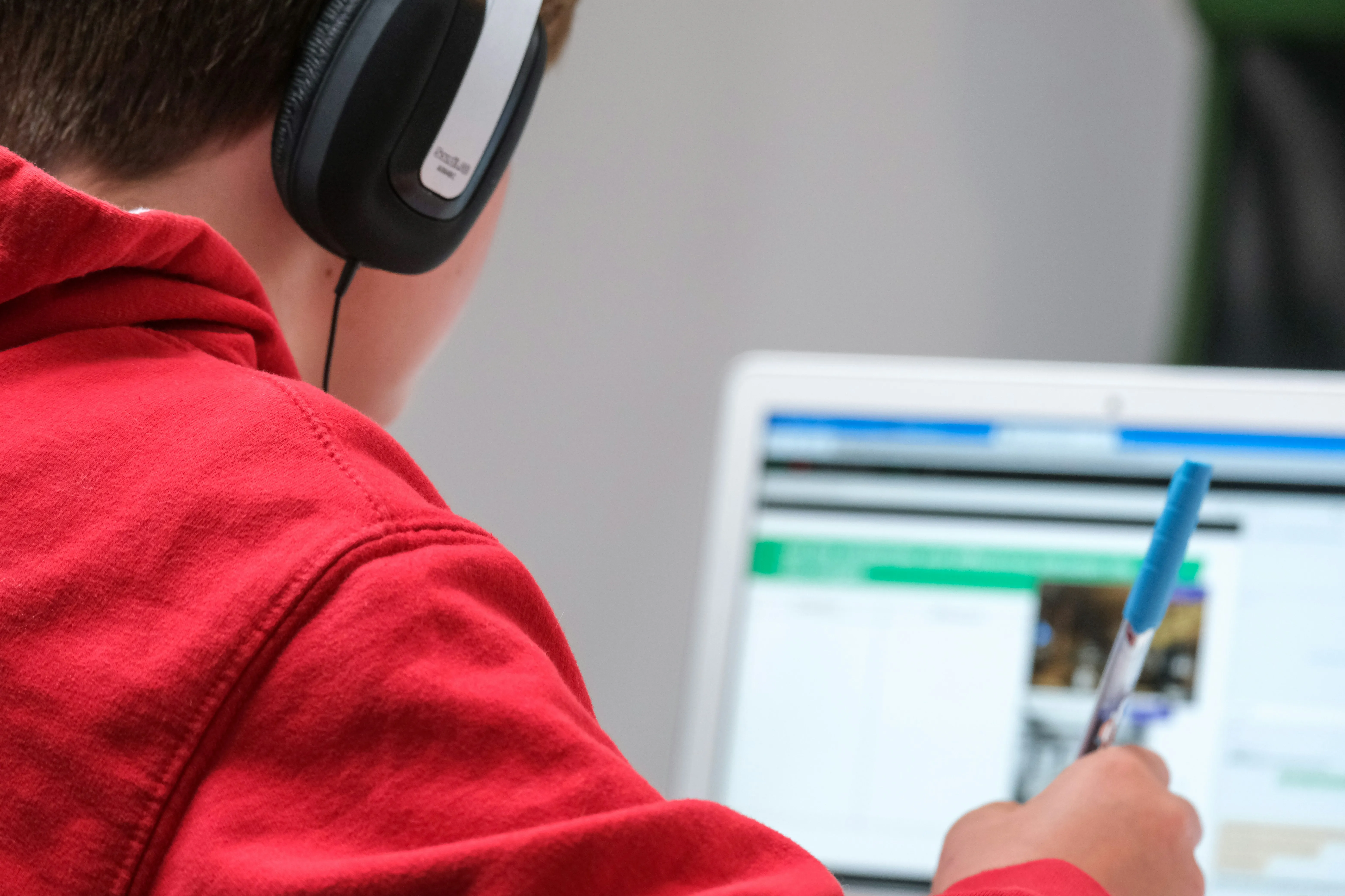Student wearing headphones and using a smartphone while studying