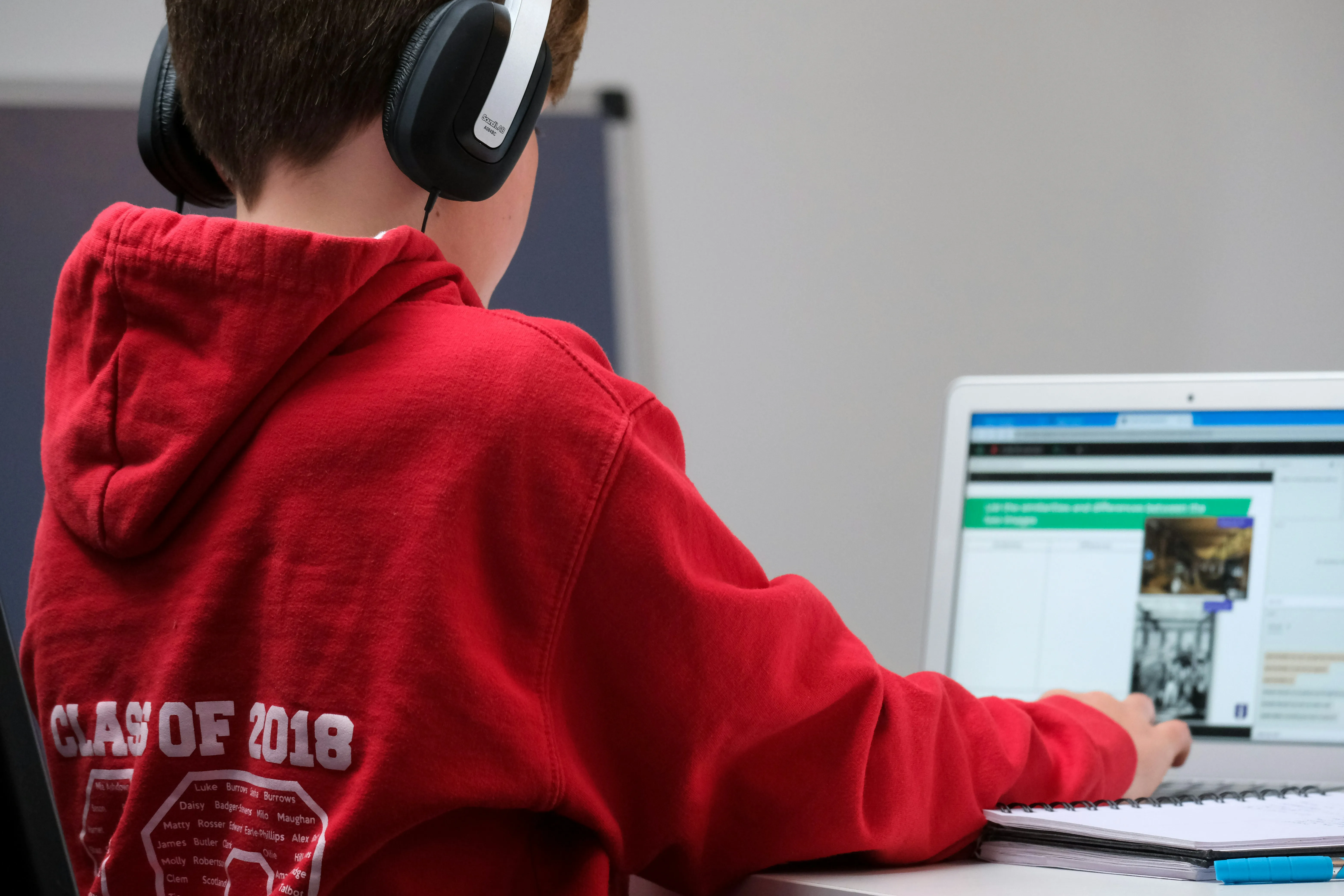 Student using a computer with books nearby
