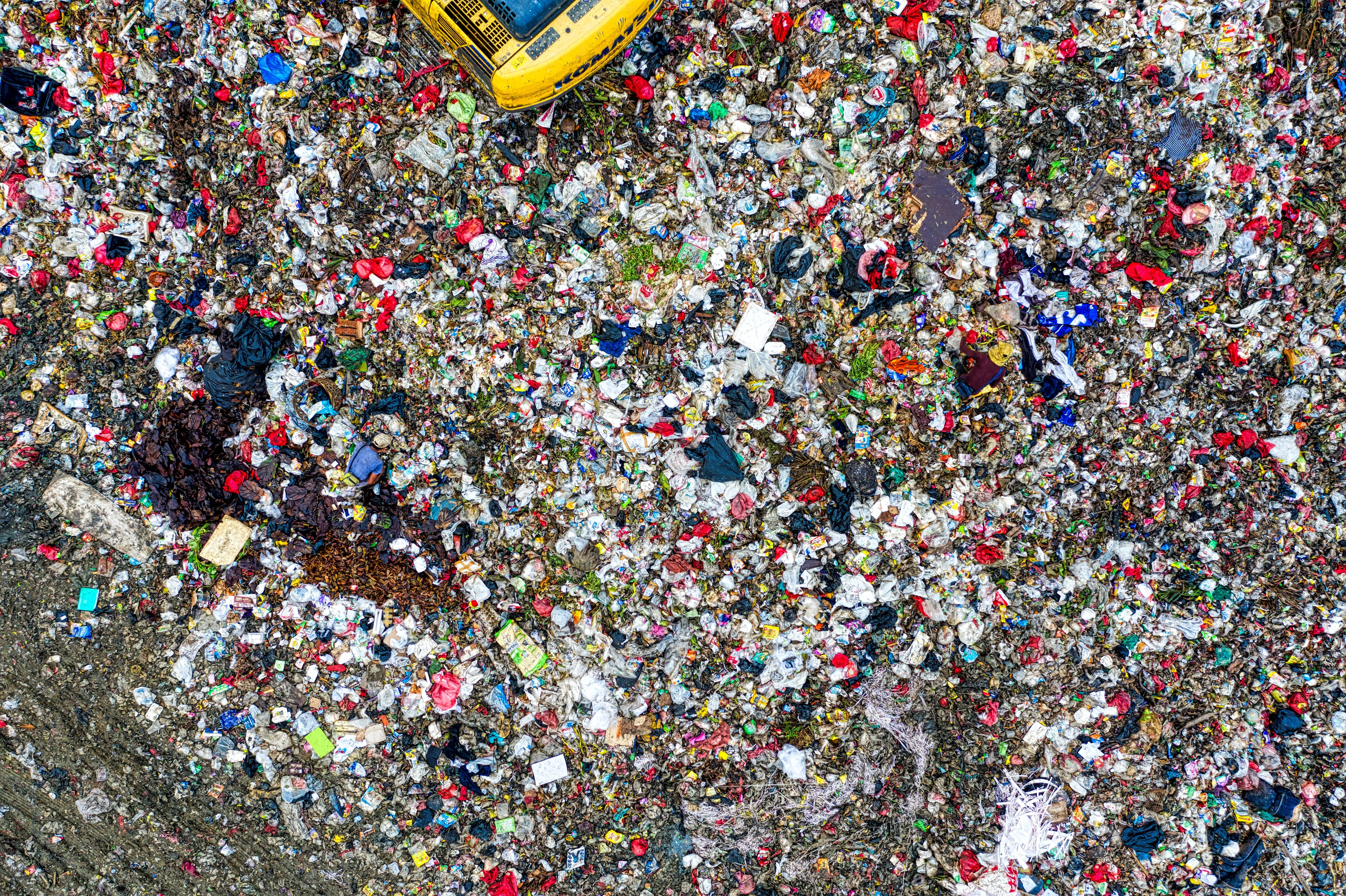 Landfill waste piled beside a bulldozer